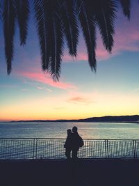 Silhouette of people at lakeshore during sunset