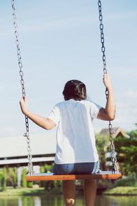 Rear view of woman on swing at playground