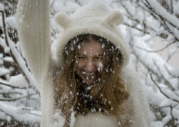 Close-up portrait of a smiling girl in snow