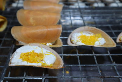 Close-up of yellow food on metal grate