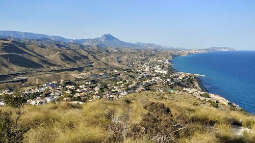 High angle view of townscape by sea against clear sky