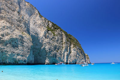 Swimming pool by sea against clear blue sky