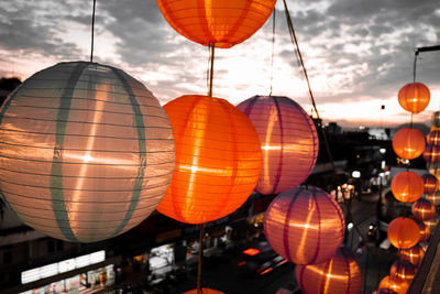 Low angle view of illuminated lanterns hanging against sky at night