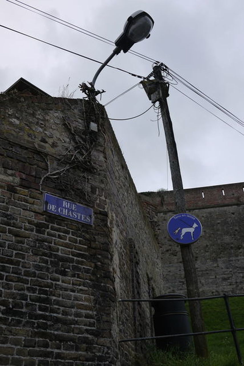 LOW ANGLE VIEW OF TEXT ON WALL AGAINST SKY