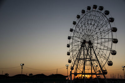 Low angle view of ferris wheel against clear sky