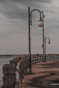 Street light on beach against sky