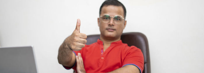 Portrait of man using mobile phone against white background