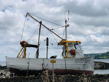 Cranes at commercial dock against sky