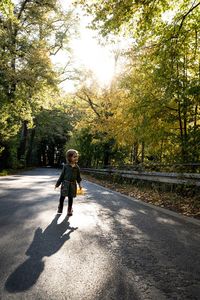 Boy on road against trees