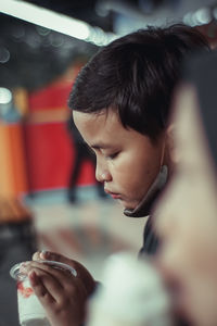 Close-up of boy blowing bubbles at home