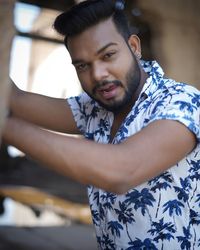 Portrait of young man standing against wall