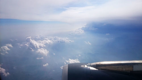 Airplane wing over sea against sky