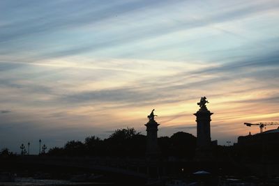 Silhouette of statue against cloudy sky