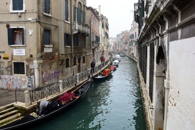 Boats in canal along buildings