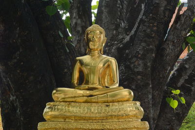 Buddha statue against tree