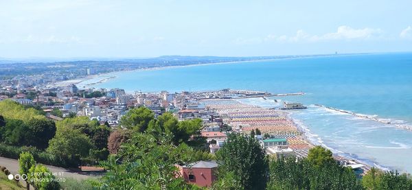 High angle view of townscape by sea against sky