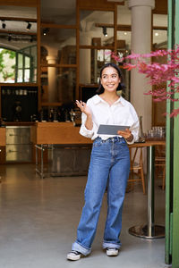 Portrait of smiling young woman standing in gym