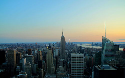 Empire state building in city during sunset