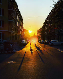 Cars on city street during sunset