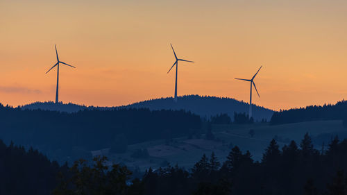 Silhouette of wind turbines at sunset