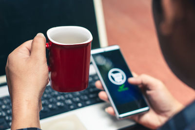 Close-up of hand holding coffee cup