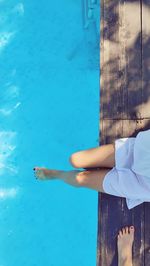 Low section of woman legs relaxing in swimming pool