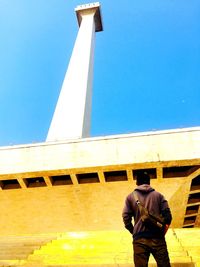 Rear view of man standing against clear sky