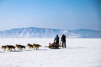 People skiing on snow covered mountain