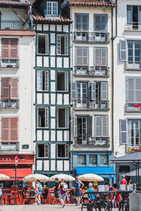 People on street against buildings in city