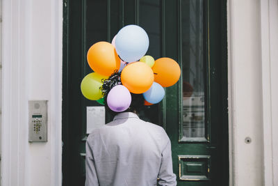 Man with balloons on window