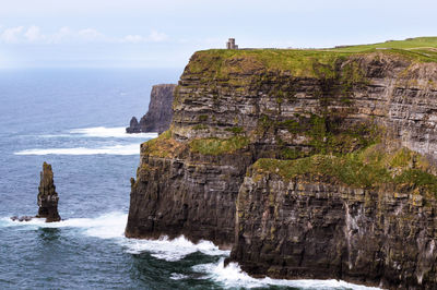 Rock formations by sea against sky