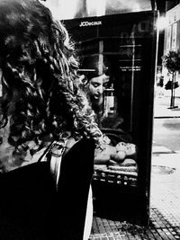 Woman holding umbrella while standing on street