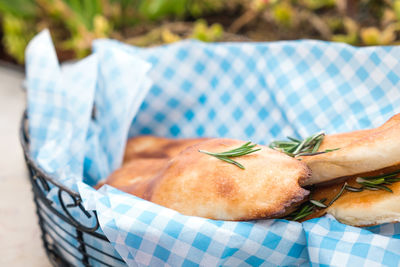 Close-up of ciabatta bread with rosemary in basket