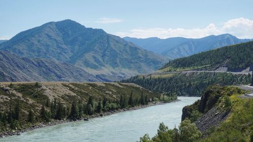 Scenic view of river amidst mountains against sky