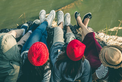 High angle view of friends sitting on jetty against water