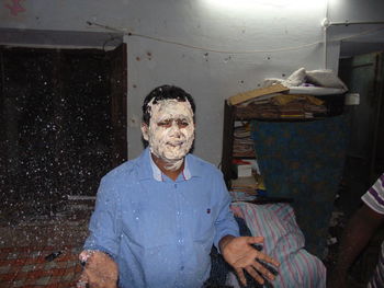 Portrait of man covered in cream celebrating at home