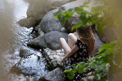 High angle view of woman sitting on rock