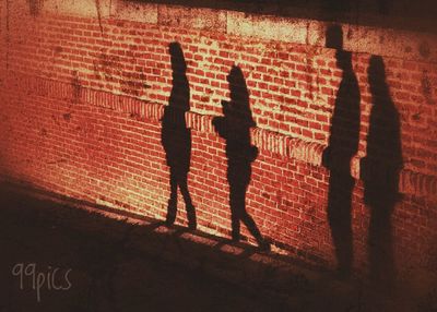 Silhouette of people standing against wall