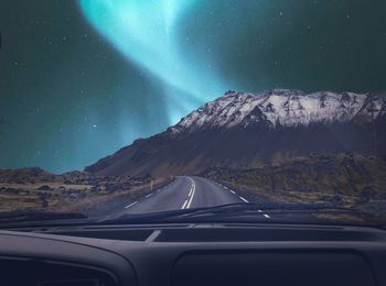 Aerial view of mountain road seen through car windshield