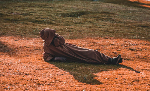 Side view of man relaxing on field