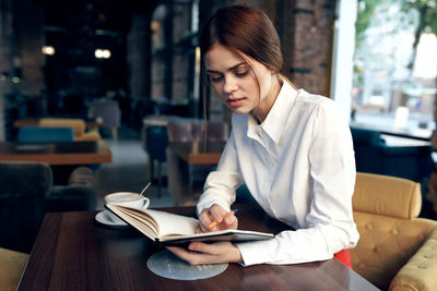 Woman sitting on table at restaurant