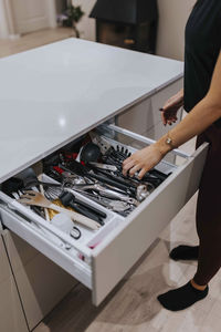 Woman's hand in open kitchen drawer