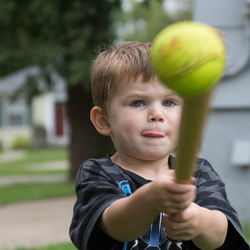 Cute boy playing baseball in yard