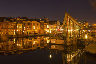 Cafe and houses reflecting on a night in leiden