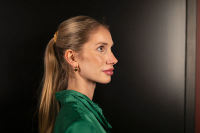 Portrait of young woman against wall