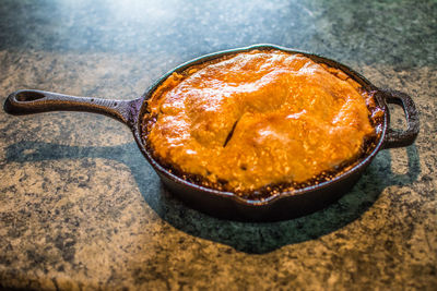 High angle view of apple pie in frying pan on kitchen counter