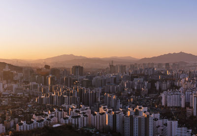 Aerial view of buildings in city during sunset