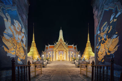 Illuminated temple building against sky at night