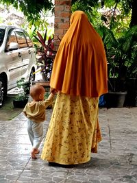 Rear view of woman with umbrella on street