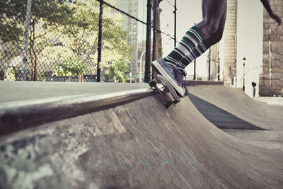 Low section of man skateboarding on road